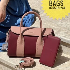 A two-tone handbag with matching wallet and detachable strap displayed on stone steps; text advertises "Kampala Bags" with a contact number. 0755951244