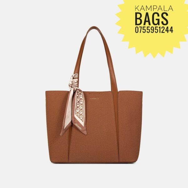 Brown leather tote bag with top handles and a patterned scarf tied to one strap, displayed on a white background. Perfect for those seeking stylish tote bags and office bags. Yellow starburst advertises "Kampala Bags 075951244.