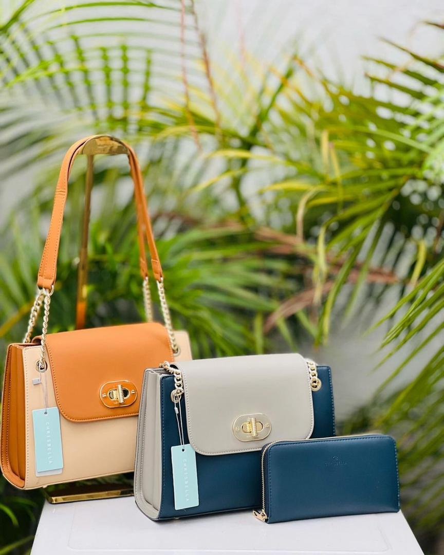 Ladies Bags 1 Three stylish handbags in orange, beige, and navy sit against a lush green backdrop of palm leaves.